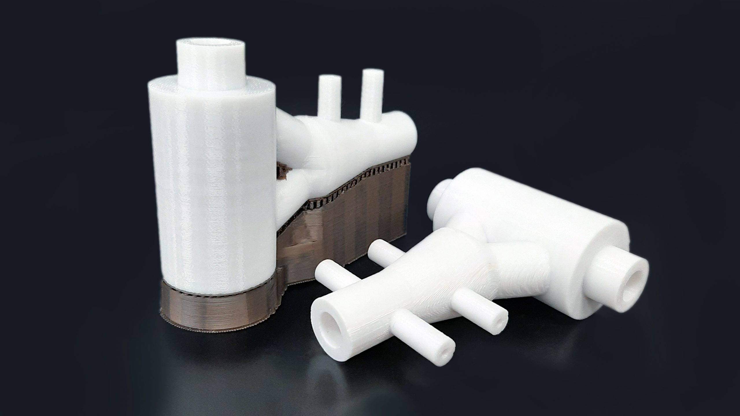 White FDM 3D printed parts, one before post-processing with brown support material and one after post-processing without brown support material.