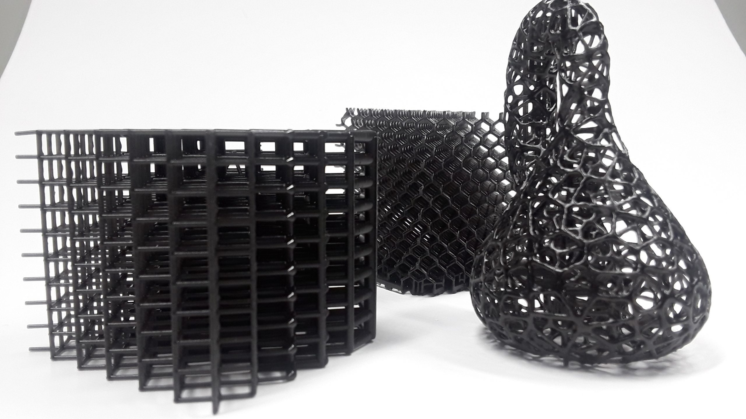 3 black resin printed parts with lattice structure.